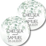 Round wedding favor labels with a soft green watercolor eucalyptus leaf design.